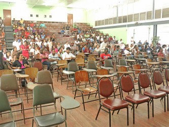 Students listen to Vice-Chancellor Jacob Opadeyi and other presenters during the consultation. Not many students were in attendance initially but the number grew as more and more trickled into the George Walcott Lecture Theatre at the Turkeyen Campus yesterday  