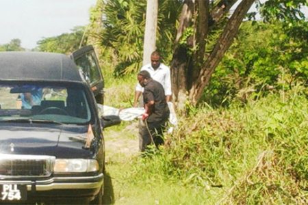 Undertakers from the Lykens Funeral Home removing the unidentified body yesterday at Le Repentir Cemetery.
