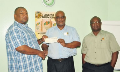  RHTYSC Secretary/CEO Hilbert Foster accepts a $200,000 sponsorship cheque from TCL Plant Manager Mark Bender while Eric Whaul looks on 