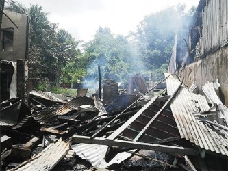 The rubble of the building that housed four families following a late night fire at Sisters Village.