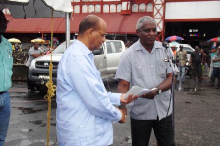 Ministry of Public Works, Robeson Benn making the symbolid handover to Home Affairs Minister, Clement Rohee.