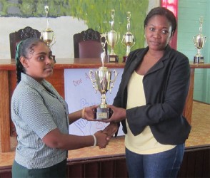 In photo: Headmistress of New Amsterdam Special Needs School Zoya Crandon-Harrison presents a trophy to Sarah Rambarran, winner of the draughts tournament.