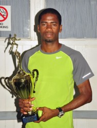 Cleveland Forde with his CARICOM 10km champion’s trophy yesterday. (Orlando Charles photo)