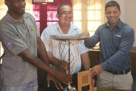 All Smiles! President of the GRFU, Peter Green (centre), national captain, Ryan Gonsalves (right) and coach/manager, Kenneth Grant-Stuart pose with the NACRA 15s title yesterday at the GOA building.
