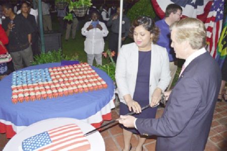 Acting Minister of Foreign Affairs Priya Manickchand and outgoing US Ambassador to Guyana, Brent Hardt cutting the cake at the 238th independence anniversary of the United States of America at the ambassador’s residence at Cummings Lodge on Wednesday evening. Manickchand’s scathing attack on the Ambassador at the event evoked loud boos and jeering from the gathering. (GINA photo)