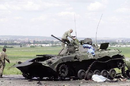 Ukrainian soldiers check a destroyed armoured vehicle at Slaviansk in eastern Ukraine yesterday. (Reuters/Maxim Zmeyev)
