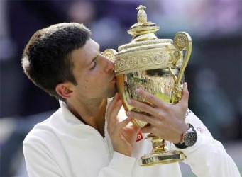 Novak Djokovic of Serbia kisses the winner’s trophy after defeating Roger Federer of Switzerland in their men’s singles final tennis match at the Wimbledon Tennis (Championships, in London yesterday. (REUTERS/Suzanne Plunkett)