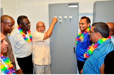 President Donald Ramotar flicking the switch. Also in photo are former West Indian Cricket Captain Clive Lloyd (third from left) and Sport Minister Dr Frank Anthony (second from right). (GINA photo) 