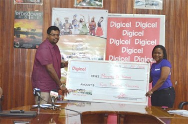  Advertising and Sales Manager of Digicel Guyana Alexis Longhorn handing over the $2 million sponsorship cheque to Minister of Tourism (ag) Irfaan Ali for the inaugural Guyana Festival. (GINA photo)