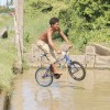 Riding on water? A youngster from Beterverwagting taking his bicycle for a spin over a trench (Photo by Arian Browne)