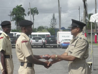  Tactical Services Unit (TSU) rank Griffith (L) receives his award from Police Commissioner Seelall Persaud (R) 