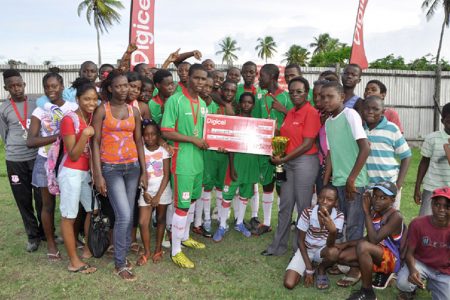 Leonora Secondary captain Scottie Leitch receiving the winner’s cheque and championship trophy from Digicel representative Natasha Taitt while members and supporters of the team look on
