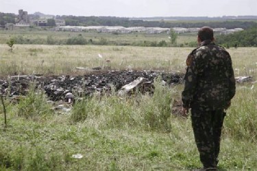 A pro-Russian separatist stands at the crash site of Malaysia Airlines Flight MH17, near the settlement of Grabovo in the Donetsk region yesterday. (REUTERS/Maxim Zmeyev)