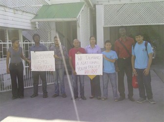 Youth activists standing in front of the Ministry of Culture, Youth and Sport building, posing for a photo with placards summarizing their demands