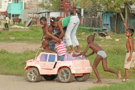 One more? Imitating an overloaded minibus, these youngster were having fun along Independence Boulevard, Albouystown yesterday. (Photo by Arian Browne)
