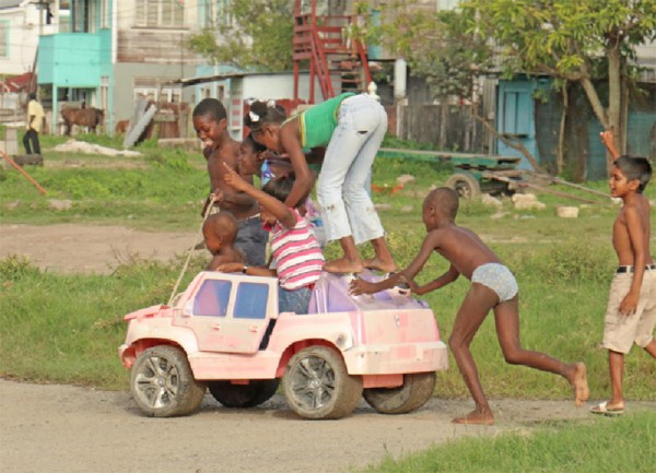 One more? Imitating an overloaded minibus, these youngster were having fun along Independence Boulevard, Albouystown yesterday. (Photo by Arian Browne) 