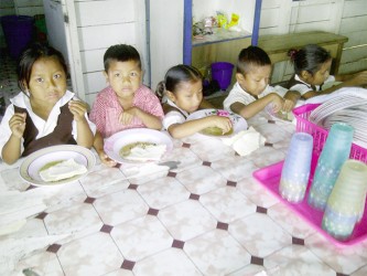 A group of school children having lunch at the hot meal dining house