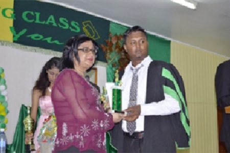A graduate collects his prize and trophy from Mrs Alli Baksh, wife of the Minister in the Ministry of Agriculture, Alli Baksh. (GINA photo)