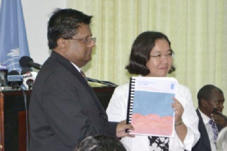 Chisa Mikami, Resident Representative (ag), UNDP (right), officially handing over a copy of the UNDP’s Human Development 2014 Report to Finance Minister, Dr. Ashni Singh last week. (GINA photo)