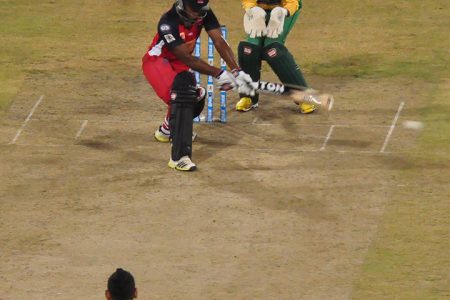 Nicholas Pooran reverse sweeps Sunil Narine for one of his two fours in last night’s action at the National Stadium.