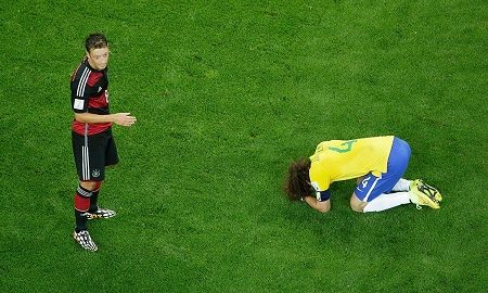 David Luiz of Brazil reacts as Mesut Oezil of Germany looks on after Germany's 7-1 win during the 2014 FIFA World Cup Brazil Semi Final match between Brazil and Germany at Estadio Mineirao on July 8, 2014 in Belo Horizonte, Brazil. (FIFA.com photo)