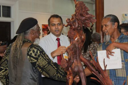 Minister Frank Anthony (centre) discussing Winslow Craig’s (right) Saving Seeds sculpture. Also in photo is Ras Leon Saul