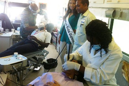 Patients receiving dental services from the GDF team. Sharir Chan is standing second from right. Third from right is Miss India-Guyana Divya Sieudarsan.
