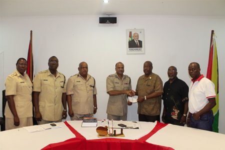 Leon Gibbons (third from right) making the presentation to Police Commissioner Seelall Persaud (Guyana Police Force photo)