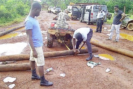 Police stationed in Mahdia remove the logs used as road barriers.
