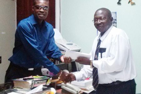 AFC General Secretary David Patterson (left) handing the motion over to Clerk of the National Assembly Sherlock Isaacs.