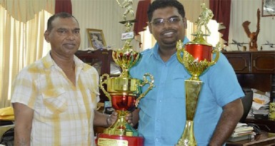  Minister of Tourism Irfaan Ali, right and Trophy Stall CEO Ramesh Sunich show off some of the trophies which will up for grabs at today’s sporting events of the Guyana Festival. 