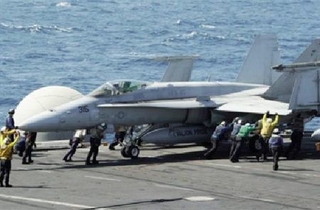 Sailors guide an F/A-18C Hornet assigned to the Valions of Strike Fighter Squadron (VFA) 15 on the flight deck of the aircraft carrier USS George H.W. Bush (CVN 77) in the Gulf, in this handout image taken and released on August 8, 2014.
