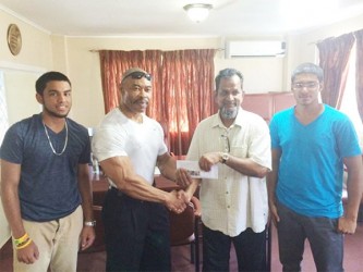 CEO of Mohamed’s Enterprise, Nazar Mohamed presenting the cheque to Hugh Ross yesterday. Mohamed is flanked by his nephews Robin Sookraj (left) and Christopher Morgan.