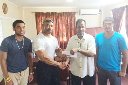 CEO of Mohamed’s Enterprise, Nazar Mohamed presenting the cheque to Hugh Ross yesterday. Mohamed is flanked by his nephews Robin Sookraj (left) and Christopher Morgan.