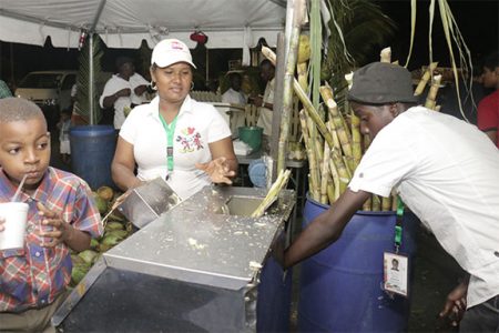 Refreshingly sweet: Quenching the thirst for cane juice on the opening day of the Guyana Festival on Friday at the National Stadium.
