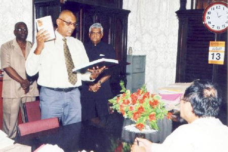 Vishnu Persaud, Deputy Chief Election Officer/Deputy Commissioner of Registration taking the Oath of Office which was administered by Chief Justice Ian Chang (seated).  Looking on are Dr. Steve Surujbally (third from left), Chairman of GECOM and Keith Lowenfield, Chief Election Officer. (GECOM photo)
