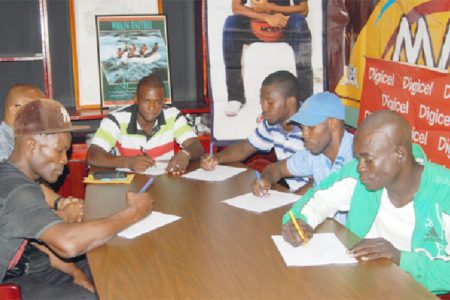 It’s official! Dexter Gonsalves (second from right) affixes his signature to his contract to make his ring date with Iwan Azore official. Other boxers signing their contracts yesterday were (from left) Derrick Richmond, (from right) Richard Williamson, Winston Pompey and Dexter Marques.