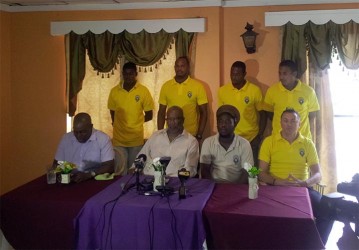 Alpha United head coach Wayne Dover (third from left sitting) addressing the gathering during the press conference while other members and players of the club inclusive of club President Odinga Lumumba (second from left sitting) look on.  
