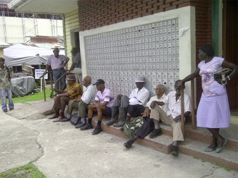 A group of pensioners waiting outside of the Bourda Post Office at lunch