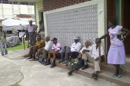 A group of pensioners waiting outside of the Bourda Post Office at lunch