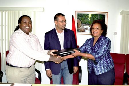 Permanent Secretary of the Ministry of Natural Resources and the Environment Joslyn Mackenzie and Guyana’s UN Resident Coordinator and UNDP Resident Representative Khadija Musa exchange copies of the signed agreement on biodiversity practices, while Minister of Natural Resources and the Environment Robert Persaud looks on. (Government Information Agency photo)