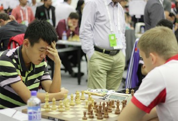 China’s opponent during the final round of the 2014 Tromso Olympiad happened to be Poland. In order to win the Men’s Olympic gold medal, the Chinese had to beat the Poles. They scored a 3-1 victory ensuring them the coveted gold medal. At left in the photo is grandmaster Ding Liren, who is concentrating on the game against his Polish opponent Grzegorz Gajewski. Ding won the game in 40 moves. 