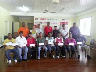 Representatives from various charitable organizations displaying their cheques in the presence of members of the organizing committee of the Guyana Independence T20 Cup, 2014. 