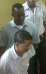 Mohammed Khan (in the front) and Linden Harry heading back to the holding cell at the Georgetown Magistrates’ Courts after their arraignment on Friday.