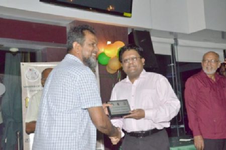 Top gold dealer: Finance Minister Dr. Ashni Singh (second from left) presents the award for top licensed gold dealer to Mohamed’s Trading proprietor. The occasion was  yesterday’s  Opening and Award ceremony of Mining Week 2014, at the Gravity Lounge, Camp Street. (GINA photo)