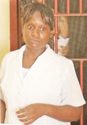 Shellon Hopkinson standing in the holding cell at the George-town Magistrates’ Courts yesterday after her arraignment.