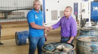 A Ministry of Natural Resources and Environment official (left) hands over four drums of fuel to PGC chairman Shawn James. (GINA photo) 