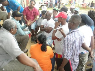 Minister of Natural Resources and the Environment Robert Persaud (centre at left) interacting with miners at Port Kaituma (GINA photo) 