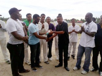 Regional Chairman, Sharma Solomon receiving a cheque and a cricket bat from secretary of the GCB, Anand Sanasie in the presence of Lancelot Easton, Rohan Sarjoo, GCB TDO, Colin Stuart and other officials and cricketers. 