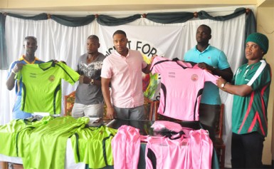 The organising committee for the “Cricket for Unity” match handing over uniforms to their two coaches. 